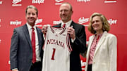 New Indiana men's basketball coach Darian DeVries poses with an Indiana basketball at Simon Skjodt Assembly Hall on March 19, 2025. Indiana athletic director Scott Dolson is on the left and Indiana president Pam Whitten is on the right.