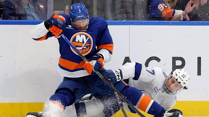 Dec 2, 2025; Elmont, New York, USA; New York Islanders right wing Maxim Tsyplakov (7) fights for the puck against Tampa Bay Lightning center Dominic James (17) during the first period at UBS Arena. Mandatory Credit: Brad Penner-Imagn Images