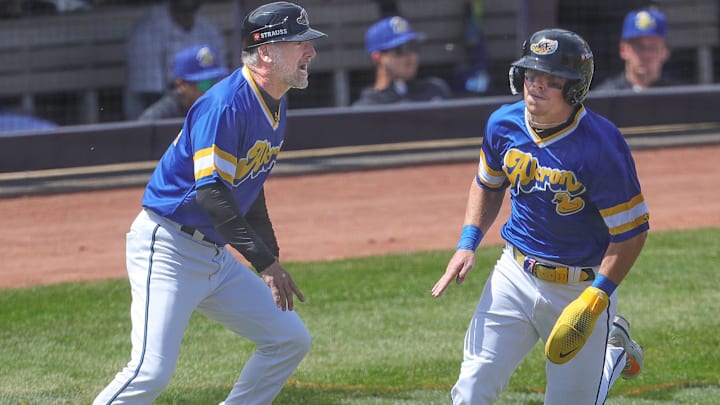 RubberDucks’ Travis Bazzana runs past manager Greg DiCenzo to score a run against the Altoona Curve on April 13, 2025, in Akron, Ohio.