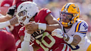 LSU Tigers safety Dashawn Spears (10) sacks Arkansas Razorbacks quarterback Taylen Green (10) during the first half at Tiger Stadium. 