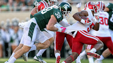 Oct 21, 2017; East Lansing, MI, USA; Indiana Hoosiers wide receiver J-Shun Harris II (5) is pulled down by Michigan State Spartans linebacker Byron Bullough (38) during the first half of a game at Spartan Stadium. Mandatory Credit: Mike Carter-Imagn Images