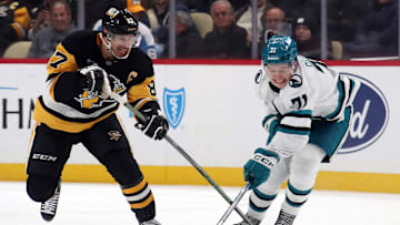 Nov 16, 2024; Pittsburgh, Pennsylvania, USA;  Pittsburgh Penguins center Sidney Crosby (87) and San Jose Sharks center Macklin Celebrini (71) battle to control the puck during the third period at PPG Paints Arena. Mandatory Credit: Charles LeClaire-Imagn Images