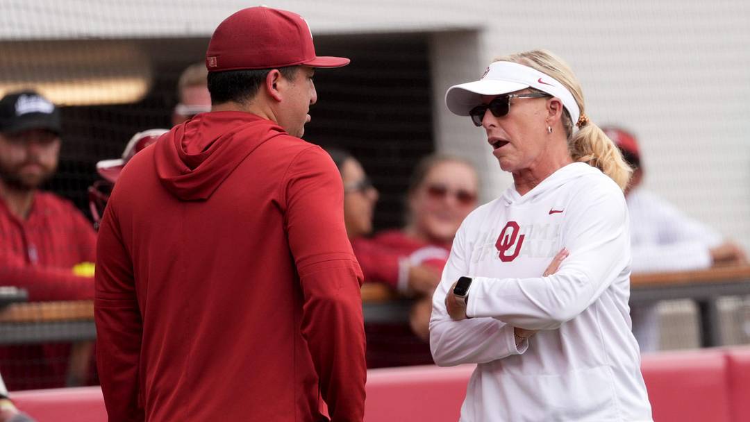 Oklahoma coach Patty Gasso talks with associate had coach JT Gasso during a contest at Love's Field.