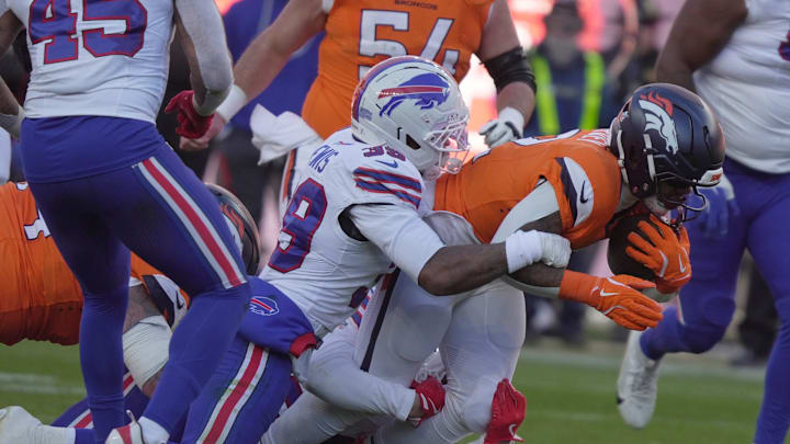 Buffalo Bills cornerback Cam Lewis with help from a teammate brings down Denver Broncos running back RJ Harvey during first half action at Empower FIeld at Mile High in Denver, Colorado on Jan. 17, 2026.