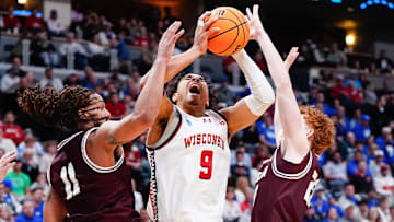 Mar 20, 2025; Montana guards Joe Pridgen (left) and Austin Patterson defend against Wisconsin guard John Tonje during a first-round game in Denver.