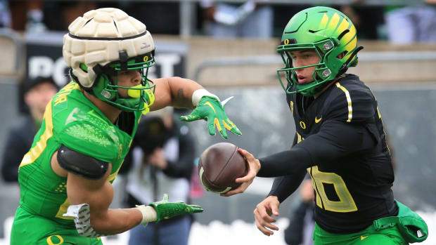 Oregon Green Team running back Jayden Limar, takes the ball from quarterback Austin Novosad during the Oregn Spring game at A