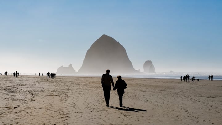 A couple walking on Cannon Beach in Oregon. 