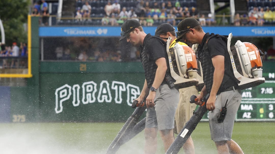 Jun 28, 2025; Pittsburgh, Pennsylvania, USA;  The PNC Park grounds crew attempts to blow rain off of the playing surface in order to resume the game against the New York Mets after a rain delay halted play in the second inning at PNC Park. Mandatory Credit: Charles LeClaire-Imagn Images