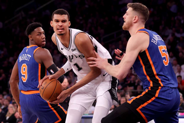 San Antonio Spurs center Victor Wembanyama (1) controls the ball against New York Knicks guard RJ Barrett (9). 