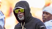 Nov 23, 2024; Kansas City, Missouri, USA;  Colorado head coach Deion Sanders watches his players warmup prior to the game between the Kansas Jayhawks and the Colorado Buffaloes at GEHA Field at Arrowhead Stadium. Mandatory Credit: Nick Tre. Smith-Imagn Images