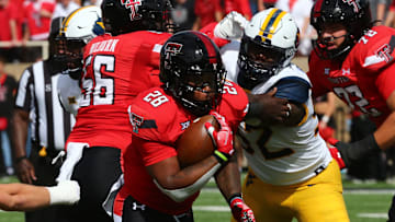 Texas Tech Red Raiders running back Tahj Brooks (28) rushes against West Virginia Mountaineers defensive lineman Asani Redwood (92).