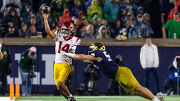 Oct 18, 2025; South Bend, Indiana, USA; Southern California Trojans quarterback Jayden Maiava (14) passes the ball under pressure by Notre Dame Fighting Irish defensive tackle Elijah Hughes (56) during the second half at Notre Dame Stadium. Mandatory Credit: Michael Caterina-Imagn Images