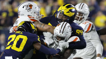 Sep 16, 2023; Ann Arbor, Michigan, USA; Bowling Green Falcons running back PaSean Wimberly (30) is tackled by Michigan Wolverines defensive lineman Cam Goode (99) and defensive back Jyaire Hill (20) in the second half at Michigan Stadium. Mandatory Credit: Rick Osentoski-USA TODAY Sports