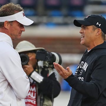 Nov 1, 2025; Oxford, Mississippi, USA; Mississippi Rebels head coach Lane Kiffin (left) talks with South Carolina Gamecocks head coach Shane Beamer during warm ups prior to the game at Vaught-Hemingway Stadium. Mandatory Credit: Petre Thomas-Imagn Images