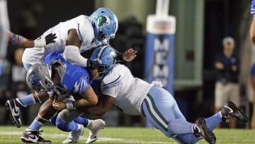 Oct 13, 2023; Memphis, Tennessee, USA; Tulane Green Wave defensive linemen Patrick Jenkins (0) and defensive linemen Darius Hodges (6) sack Memphis Tigers quarterback Seth Henigan (2) during the second half at Simmons Bank Liberty Stadium. 