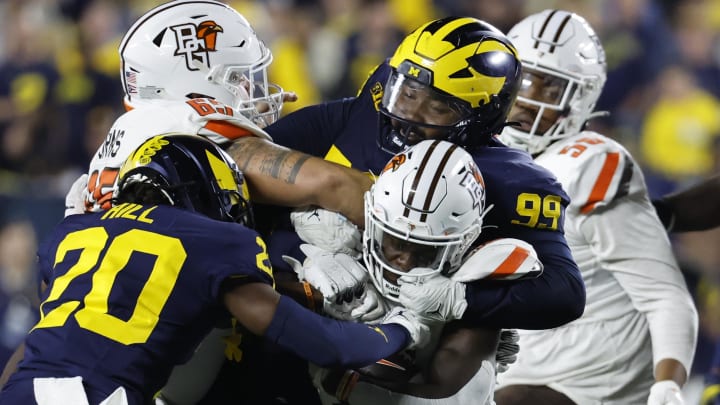 Sep 16, 2023; Ann Arbor, Michigan, USA; Bowling Green Falcons running back PaSean Wimberly (30) is tackled by Michigan Wolverines defensive lineman Cam Goode (99) and defensive back Jyaire Hill (20) in the second half at Michigan Stadium. Mandatory Credit: Rick Osentoski-USA TODAY Sports