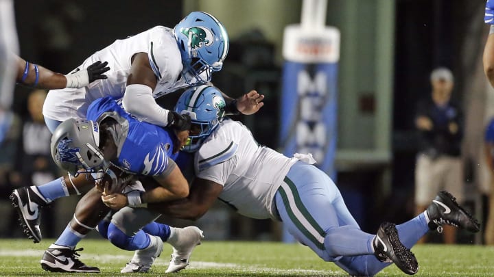 Oct 13, 2023; Memphis, Tennessee, USA; Tulane Green Wave defensive linemen Patrick Jenkins (0) and defensive linemen Darius Hodges (6) sack Memphis Tigers quarterback Seth Henigan (2) during the second half at Simmons Bank Liberty Stadium. 