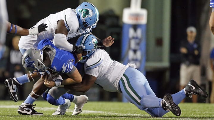 Oct 13, 2023; Memphis, Tennessee, USA; Tulane Green Wave defensive linemen Patrick Jenkins (0) and defensive linemen Darius Hodges (6) sack Memphis Tigers quarterback Seth Henigan (2) during the second half at Simmons Bank Liberty Stadium.