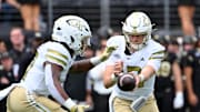 Sep 27, 2025; Winston-Salem, North Carolina, USA;  Georgia Tech Yellow Jackets quarter back Haynes King (10) hands the ball to running back Malachi Hosley (0) during the first quarter against the Wake Forest Demon Deacons at Allegacy Federal Credit Union Stadium. Mandatory Credit: Zachary Taft-Imagn Images