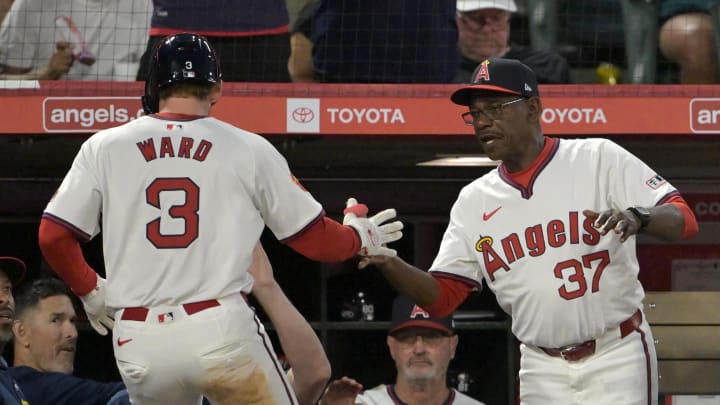 Jul 30, 2024; Anaheim, California, USA; Los Angeles Angels left fielder Taylor Ward (3) is greeted at the dugout by manager Ron Washington (37) after scoring on a single by catcher Matt Thaiss (21) in the fourth inning at Angel Stadium. Mandatory Credit: Jayne Kamin-Oncea-USA TODAY Sports