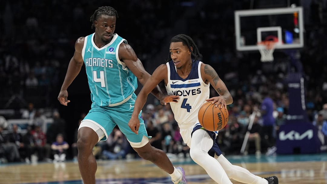 Rob Dillingham of the Timberwolves driving past a Hornets defender.