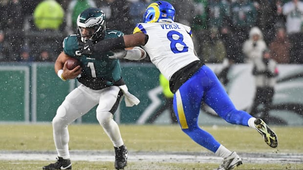 Los Angeles Rams defensive end (white and blue uniform) goes after Eagles QB Jalen Hurts.