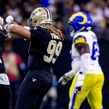 Dec 1, 2024; New Orleans, Louisiana, USA;  New Orleans Saints cornerback Alontae Taylor (1) and defensive end Chase Young (99) react to forcing a fourth down against the Los Angeles Rams during the first half at Caesars Superdome. Mandatory Credit: Stephen Lew-Imagn Images