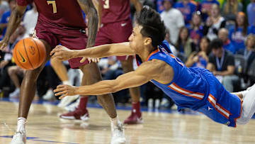 Florida guard Xaivian Lee (1) passes as he tripps against Florida State during the second half of an NCAA men's basketball game at Exactec Arena at the Steven C. O Connell Center in Gainesville, FL.