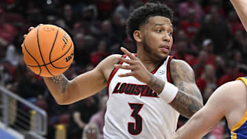 Nov 4, 2024; Louisville, Kentucky, USA;  Louisville Cardinals guard Koren Johnson (3) looks to pass again Morehead State Eagles guard Kade Ruegsegger (3) during the second half at KFC Yum! Center. Louisville defeated Morehead State 93-45. Mandatory Credit: Jamie Rhodes-Imagn Images