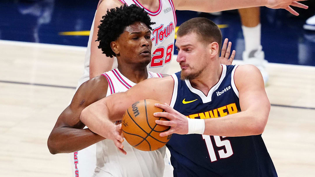 Dec 15, 2025; Denver, Colorado, USA; Denver Nuggets center Nikola Jokic (15) drives at Houston Rockets guard Amen Thompson (1) in the third quarter at Ball Arena.
