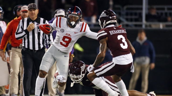 Nov 23, 2023; Starkville, Mississippi, USA; Mississippi Rebels wide receiver Tre Harris (9) runs after a catch as Mississippi State Bulldogs defensive backs Marcus Banks (1) and Decamerion Richardson (3) make the tackle during the first half at Davis Wade Stadium at Scott Field. Mandatory Credit: Petre Thomas-USA TODAY Sports