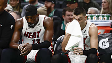 Dec 2, 2024; Boston, Massachusetts, USA; Miami Heat players (left to right) center Bam Adebayo (13), guard Tyler Herro (14), guard Terry Rozier (2) and forward Duncan Robinson (55) sit on the bench during the fourth quarter of their loss to the Boston Celtics at TD Garden. Mandatory Credit: Winslow Townson-Imagn Images