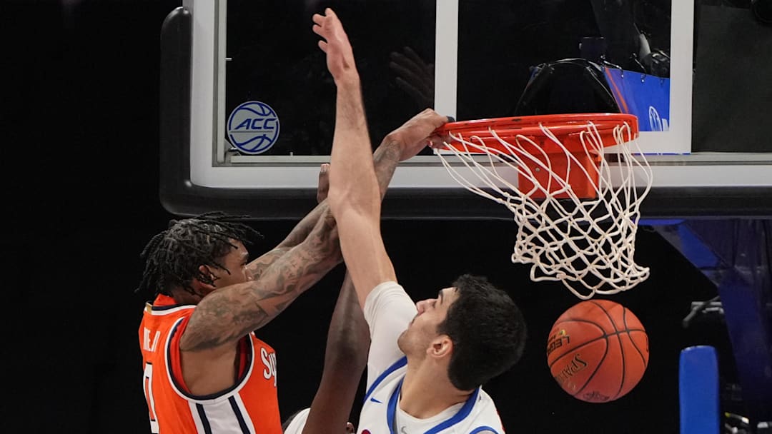 Mar 10, 2026; Charlotte, NC, USA; Syracuse Orange forward Sadiq White Jr. (0) scores as Southern Methodist University Mustangs center Samet Yigitoglu (24) defends in the second half at Spectrum Center. Mandatory Credit: Bob Donnan-Imagn Images