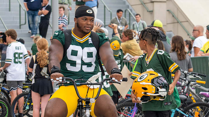 Green Bay Packers defensive end Barryn Sorrell (99) rides a young fan’s bicycle to practice at the Ray Nitschke Field during the second day of training camp on Thursday, July 24, 2025, in Ashwaubenon, Wis.