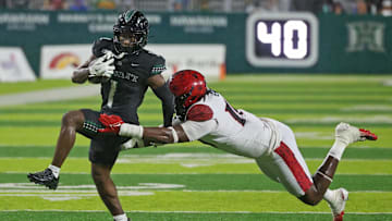 Nov 8, 2025; Honolulu, Hawaii, USA; San Diego State Aztecs defensive lineman Ryan Henderson (10) tries to pull down Hawaii Rainbow Warriors wide receiver Brandon White (1).