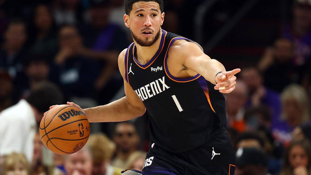 Apr 17, 2026; Phoenix, Arizona, USA; Phoenix Suns guard Devin Booker (1) against the Golden State Warriors during the first half in the play-in rounds of the 2026 NBA Playoffs at Mortgage Matchup Center. Mandatory Credit: Mark J. Rebilas-Imagn Images