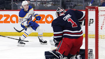 Mar 23, 2025; Winnipeg, Manitoba, CAN; Buffalo Sabres right wing Jack Quinn (22) takes a shot on Winnipeg Jets goaltender Eric Comrie (1) in the first period at Canada Life Centre. Mandatory Credit: James Carey Lauder-Imagn Images