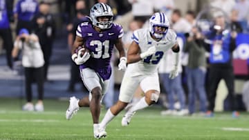 Sep 21, 2024; Provo, Utah, USA; Kansas State Wildcats running back DJ Giddens (31) runs the ball against Brigham Young Cougars defensive end Isaiah Bagnah (13) during the third quarter at LaVell Edwards Stadium. Mandatory Credit: Rob Gray-Imagn Images