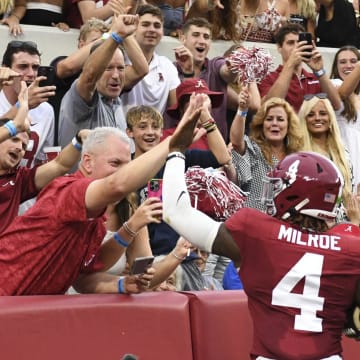 Aug 31, 2024; Tuscaloosa, Alabama, USA;  Alabama Crimson Tide quarterback Jalen Milroe (4) celebrates with fans after scoring against the Western Kentucky Hilltoppers during the first half at Bryant-Denny Stadium.  Mandatory Credit: Gary Cosby Jr.-USA TODAY Sports