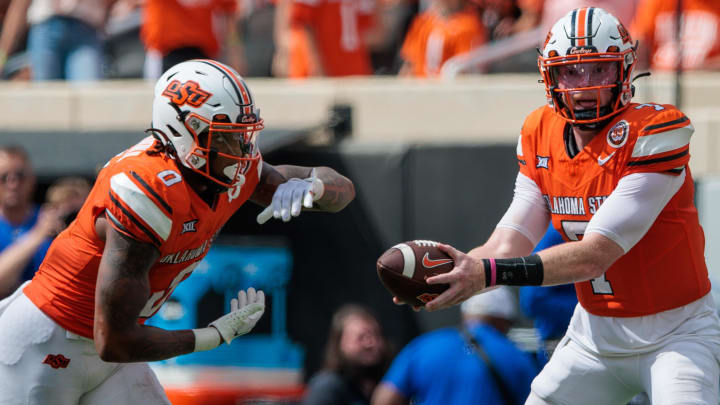 Oklahoma State Cowboys quarterback Alan Bowman (7) hands off to Oklahoma State Cowboys running back Ollie Gordon II (0) during the fourth quarter against the South Dakota State Jackrabbits at Boone Pickens Stadium.