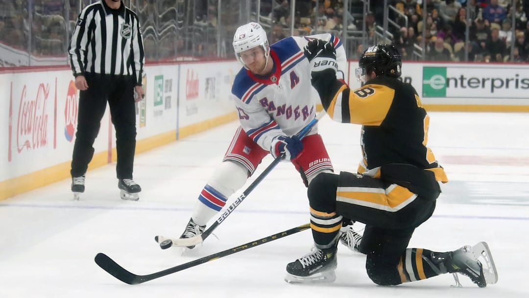 Alexis Lafreniere plays the puck against the Pittsburgh Penguins; Mandatory Credit: Charles LeClaire-Imagn Images