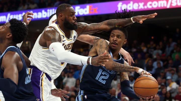 Memphis Grizzlies guard Ja Morant (12) passes the ball as Los Angeles Lakers forward LeBron James (6) defends during the second half during game one of the 2023 NBA playoffs at FedExForum. Mandatory Credit: