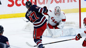 Feb 4, 2025; Winnipeg, Manitoba, CAN;  Carolina Hurricanes goalie Pyotr Kocketkov (52) makes a save on a shot by Winnipeg Jets forward Nikolaj Ehlers (27) during the third period at Canada Life Centre. Mandatory Credit: Terrence Lee-Imagn Images