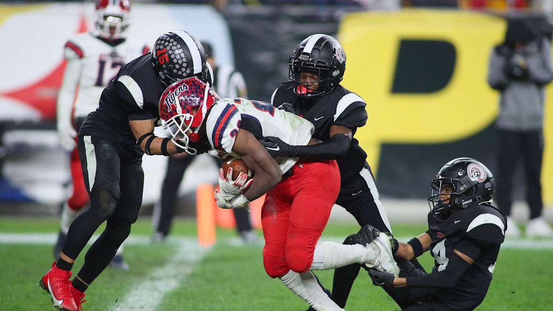 Aliquippa's QaLil Goode (14), Gavin Wilcox (13), and Arison Walker (15) attempt to hold back McKeesport's Kemon Spell (20) from scoring a touchdown during the second half of the WPIAL 4A Championship game Friday evening at Acrisure Stadium in Pittsburgh, PA. Aliquippa's QaLil Goode (14), Gavin Wilcox (13), and Arison Walker (15) attempt to hold back McKeesport's Kemon Spell (20) from scoring a touchdown during the second half of the WPIAL 4A Championship game Friday evening at Acrisure Stadium in Pittsburgh, PA.