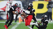 Aliquippa's QaLil Goode (14), Gavin Wilcox (13), and Arison Walker (15) attempt to hold back McKeesport's Kemon Spell (20) from scoring a touchdown during the second half of the WPIAL 4A Championship game Friday evening at Acrisure Stadium in Pittsburgh, PA.