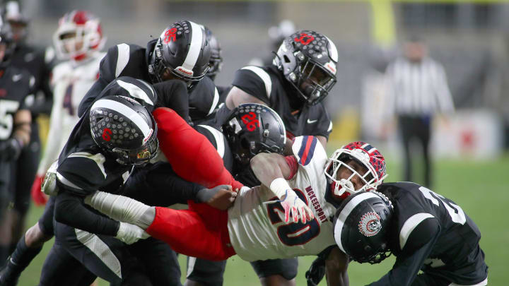 McKeesport's Kemon Spell (20) gets taken to the ground by multiple Aliquippa defenders during the second half of the WPIAL 4A Championship game Friday evening at Acrisure Stadium in Pittsburgh, PA.