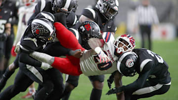 McKeesport's Kemon Spell (20) gets taken to the ground by multiple Aliquippa defenders during the second half of the WPIAL 4A Championship game Friday evening at Acrisure Stadium in Pittsburgh, PA.