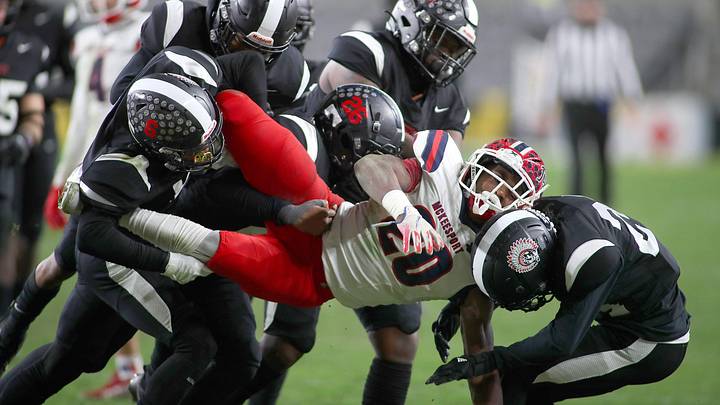 McKeesport's Kemon Spell (20) gets taken to the ground by multiple Aliquippa defenders during the second half of the WPIAL 4A Championship game Friday evening at Acrisure Stadium in Pittsburgh, PA.