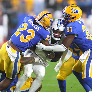 North Carolina Tar Heels George Pettaway (23) gets wrapped up by Pittsburgh Panthers Solomon DeShields (23), Rasheem Biles (31) and Donovan McMillon (3) during the first half at Acrisure Stadium in Pittsburgh, PA on September 23, 2023.