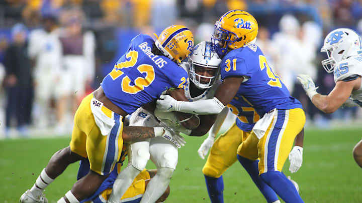 North Carolina Tar Heels George Pettaway (23) gets wrapped up by Pittsburgh Panthers Solomon DeShields (23), Rasheem Biles (31) and Donovan McMillon (3) during the first half at Acrisure Stadium in Pittsburgh, PA on September 23, 2023.